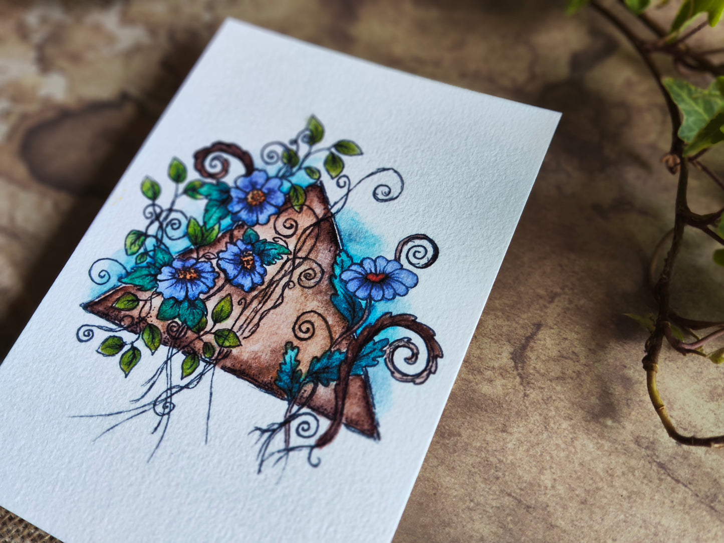 Carte A6 triangle vintage – Illustration à l’aquarelle de fleurs violettes et feuillage autour d’une forme ancienne, botanique féerique