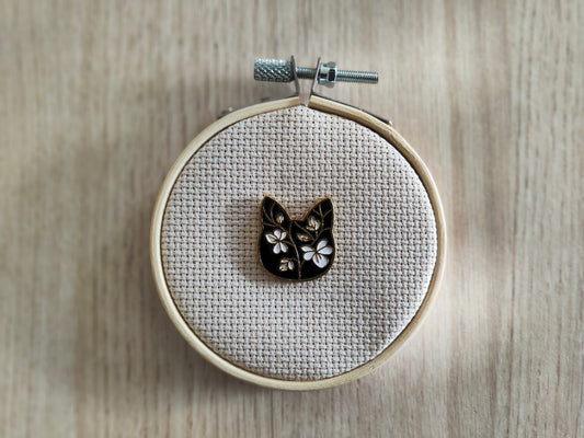 Pin's tête chat noir fleurs blanche
